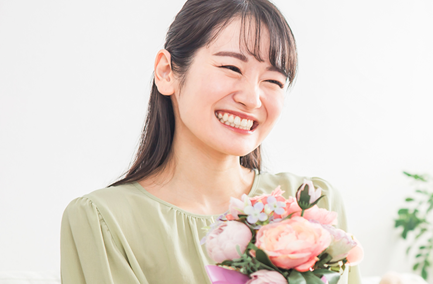 ピンク系の花束を持った女性の画像